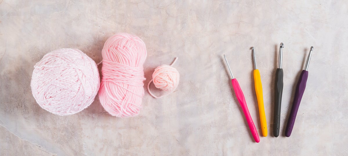 Mesa con herramientas de tejido — lanas, agujas y bastidor para distintas técnicas