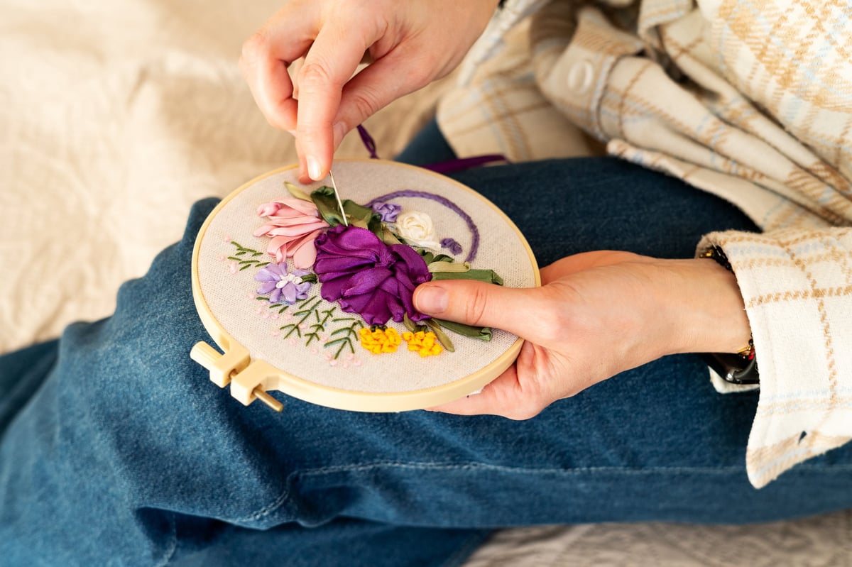 Diseños florales bordados a mano sobre tela con bastidor