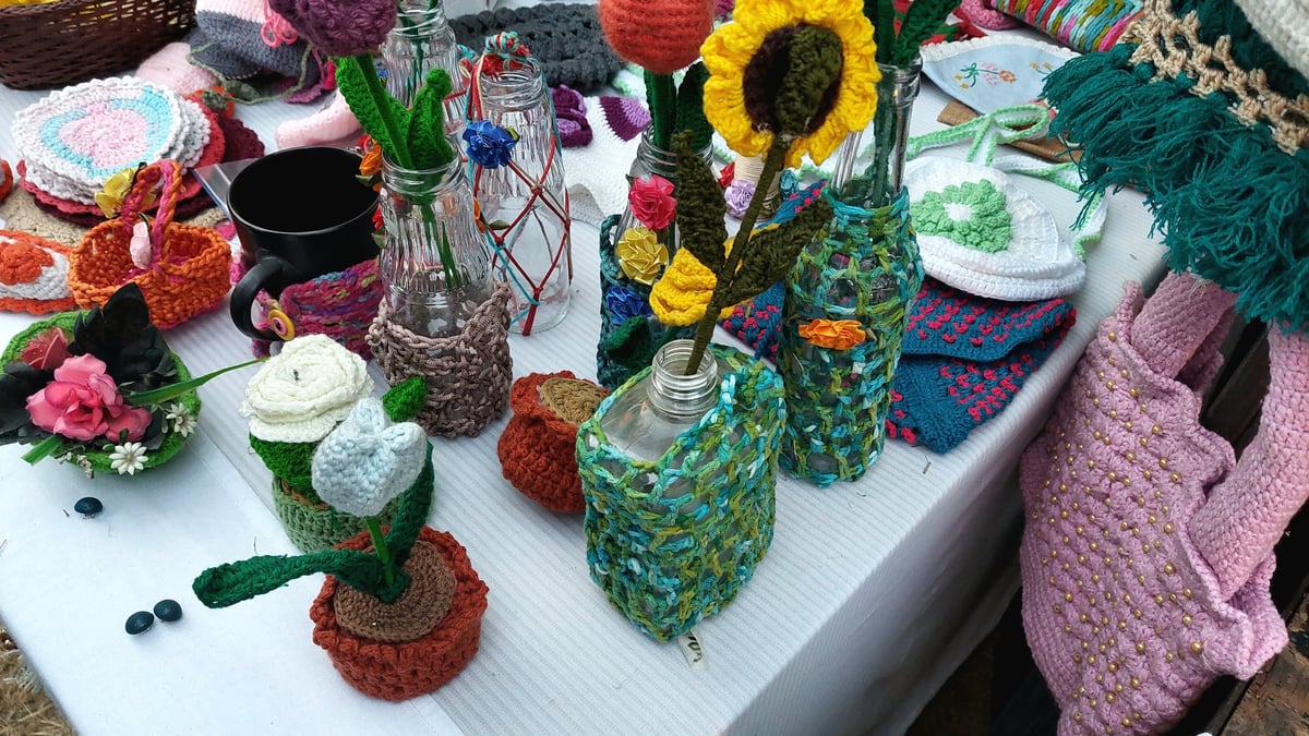 Flores y accesorios de crochet coloridos en puesto de feria creativa