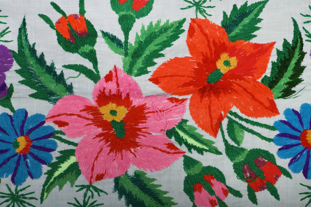 Patrón floral artesanal bordado a mano con hilos de lana de colores