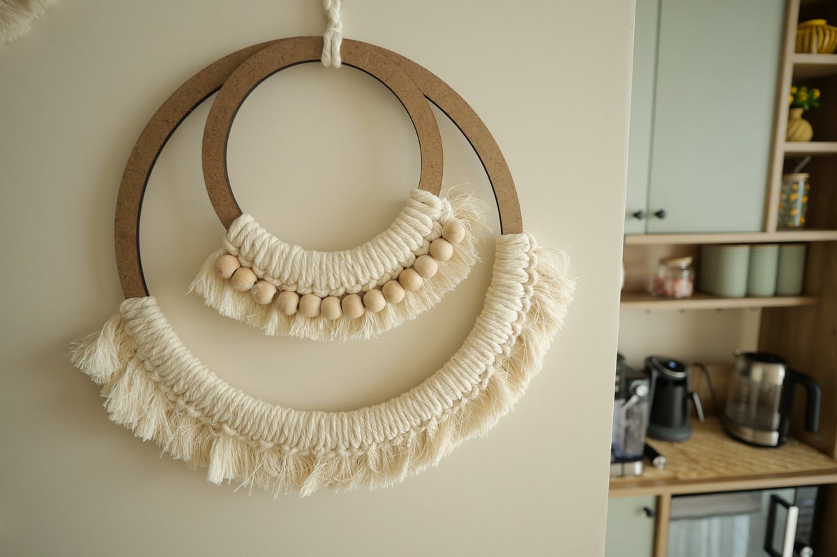 Tapiz de macramé decorativo con cuentas de madera en pared blanca