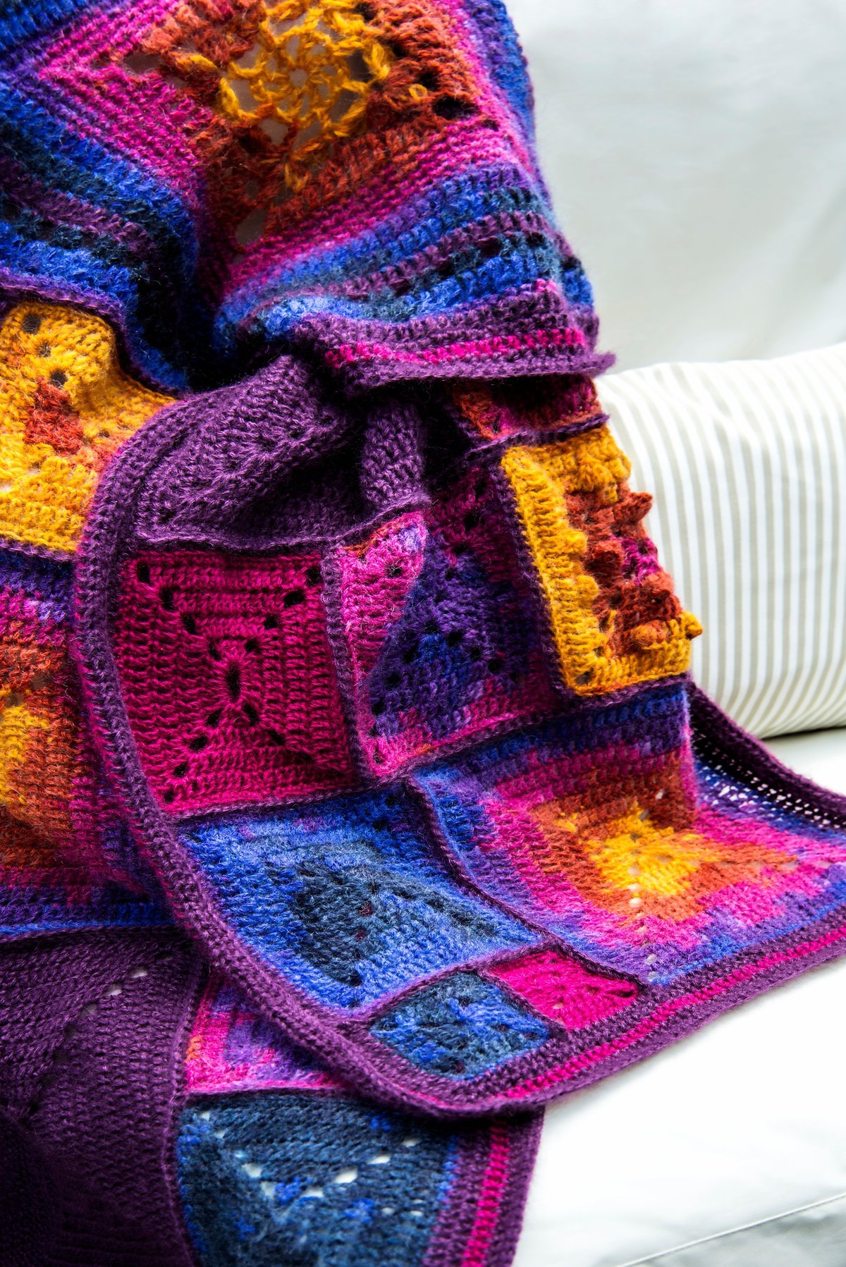 Manta de granny squares multicolor sobre sofá